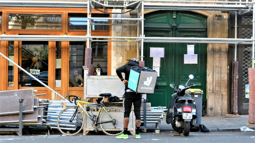 Cyclist riding through a city street doing active commuting side hustles